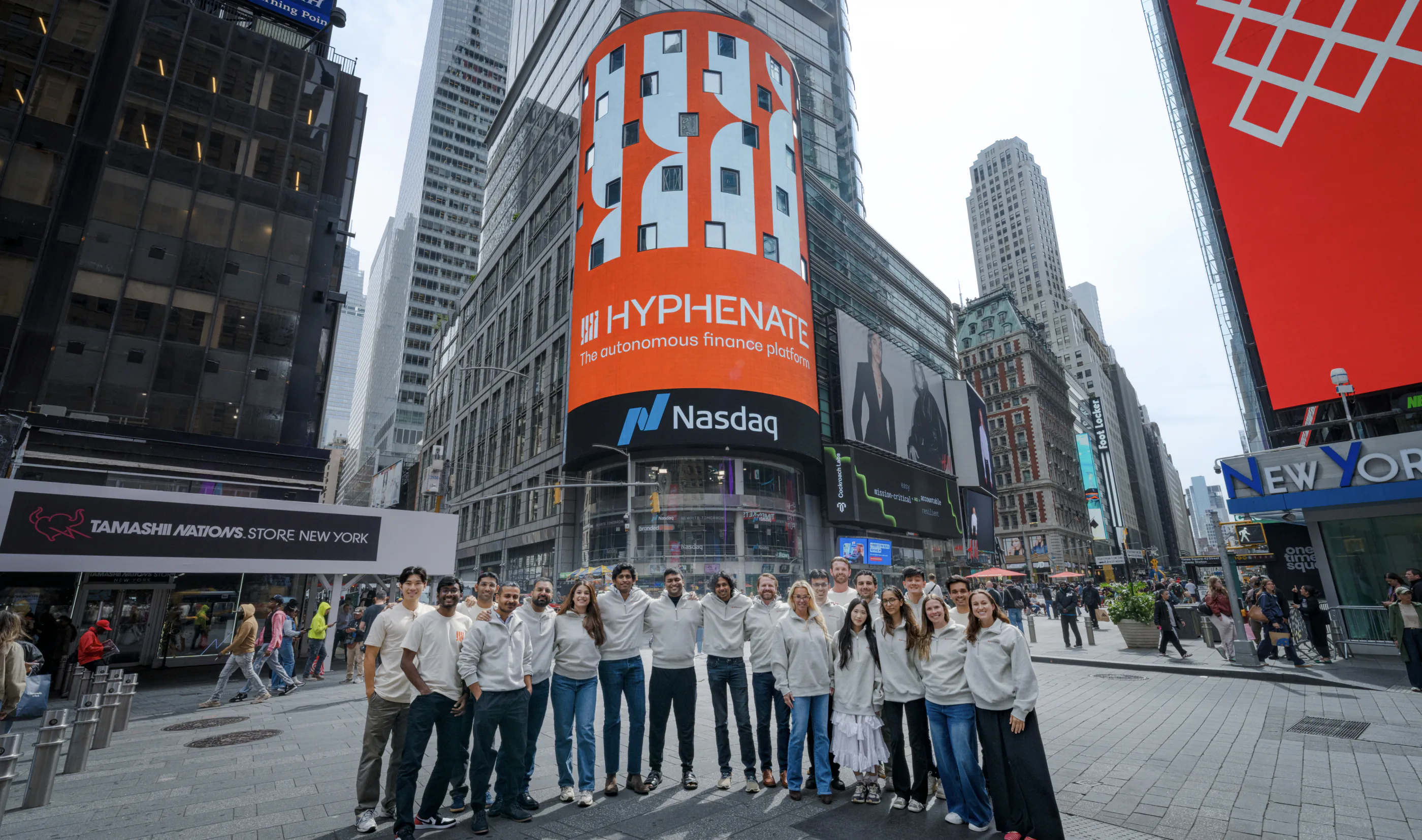 The Hyphenate team in Times Square beneath the Nasdaq tower displaying the Hyphenate billboard